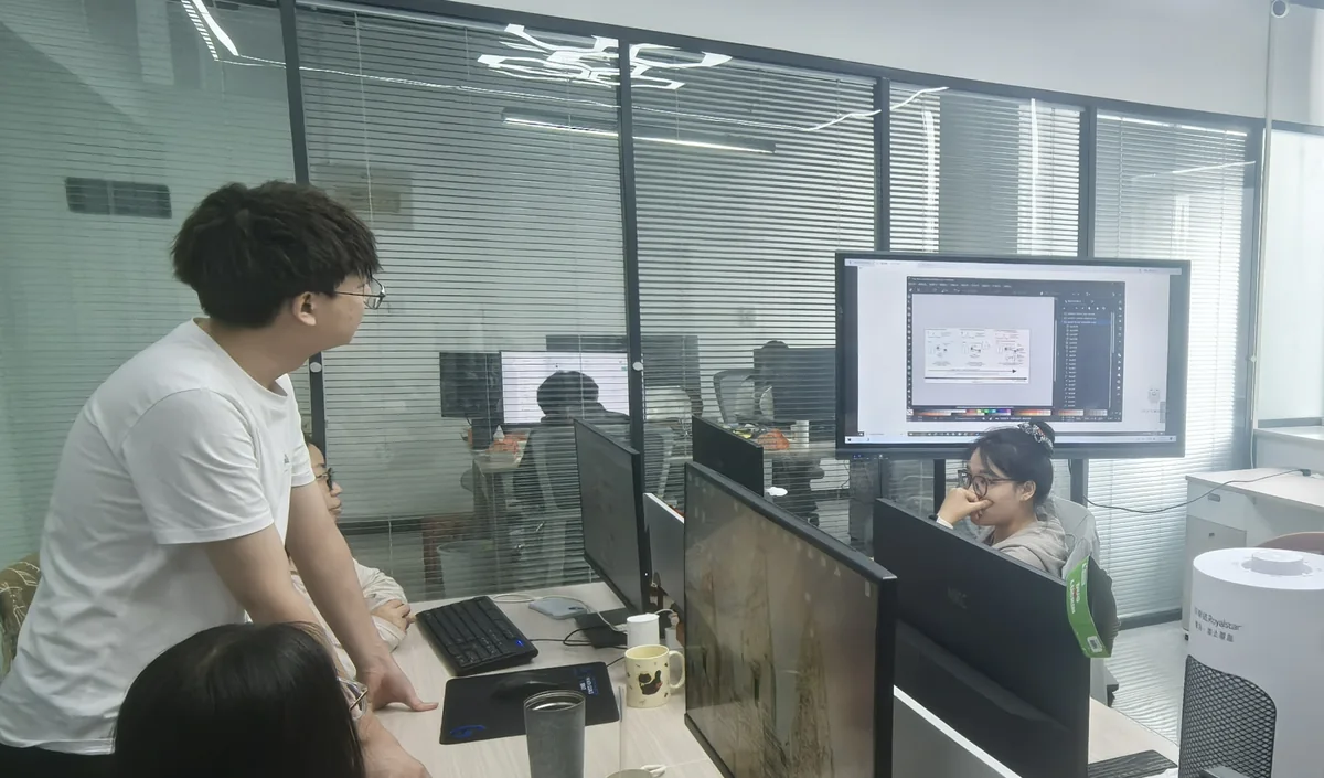 A colleague walking the team through work on screen at their desks.