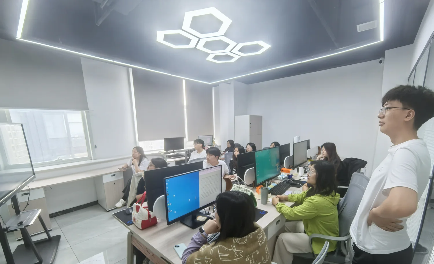 The team gathered at their desks while a colleague talks through the work.