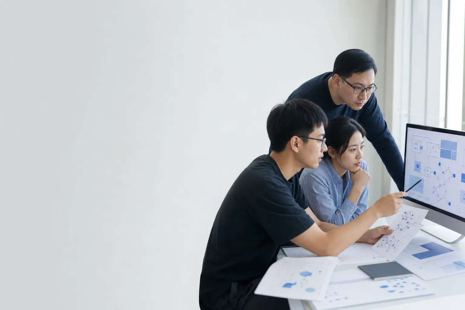 Researchers and engineers collaborating around a shared project table.